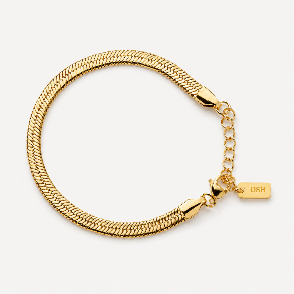 Gold chain bracelet with a tag on a white background