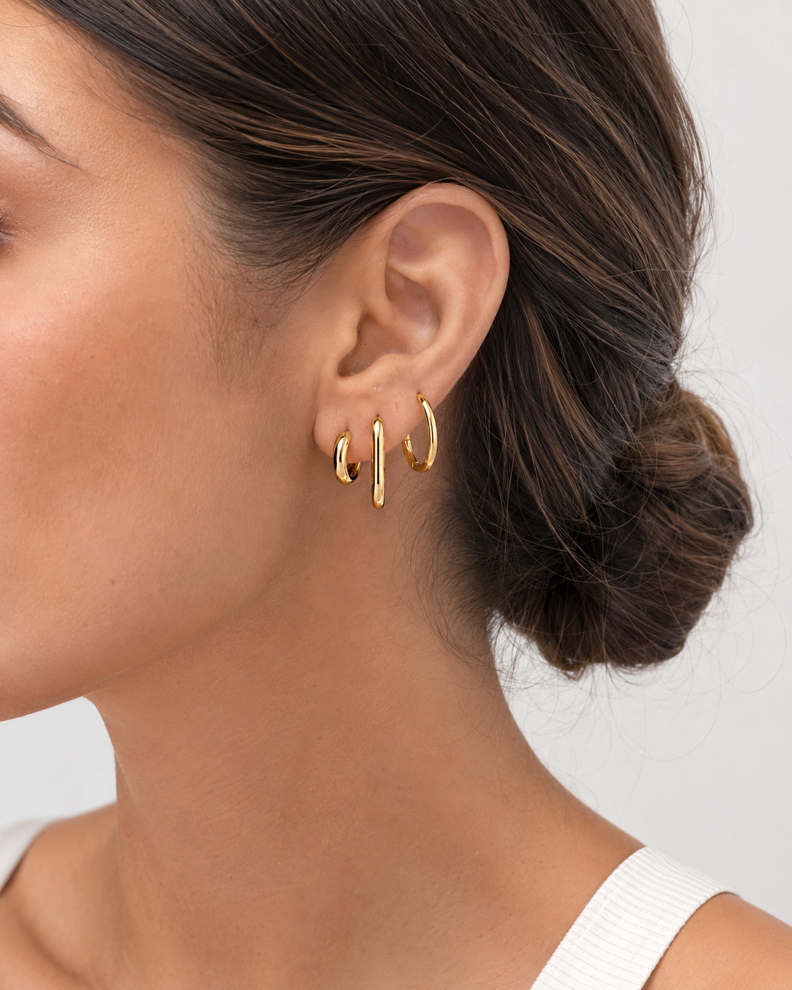 Three gold hoop styles from The Everyday Hoops Bundle worn together on ear. styled