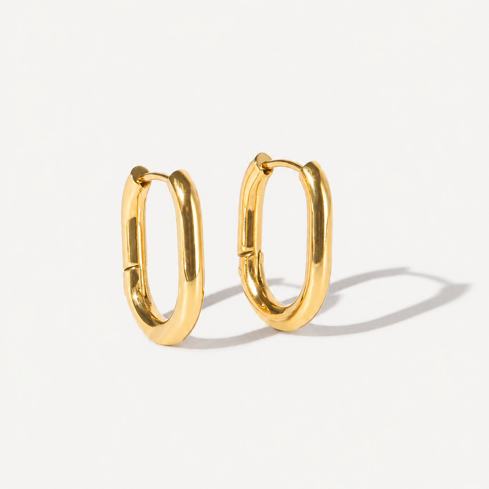 Gold hoop earrings on a light gray background