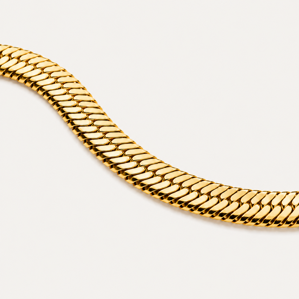 Gold chain necklace on a light gray background