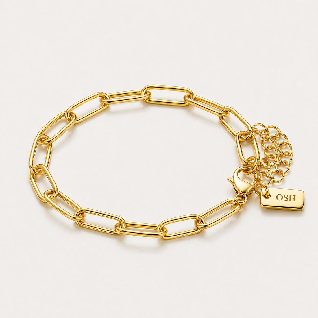 Gold chain bracelet with a lock charm on a light grey background